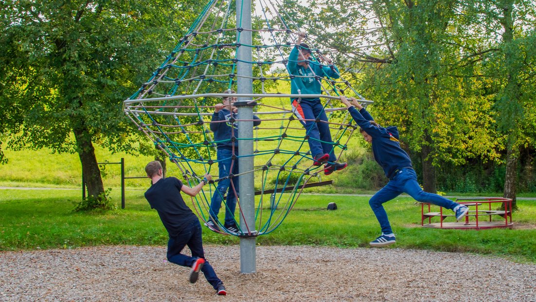 Les jeunes s’amusent ensemble sur un carrousel d’escalade.