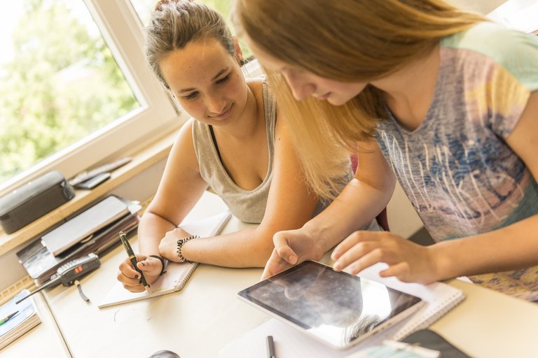 Deux filles à l’heure de travail à l’aide d’une tablette