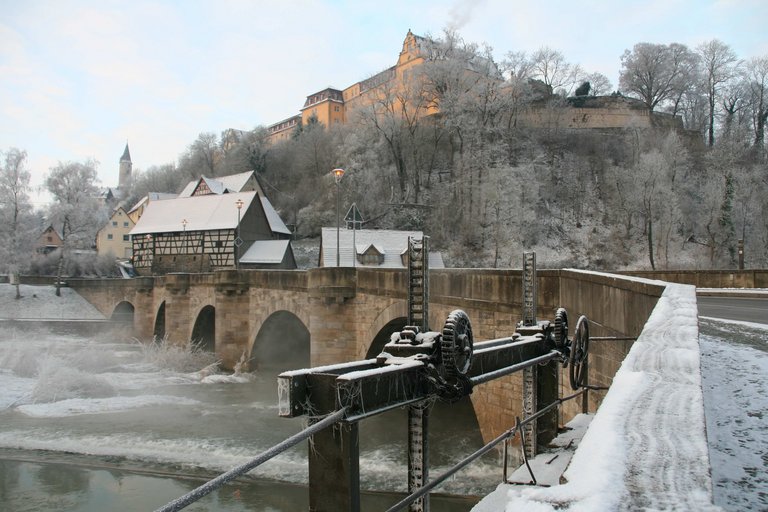 Vue hivernale vers le pont de pierre avec arches rondes et déversoir sur le Schloss-Berg Kirchberg