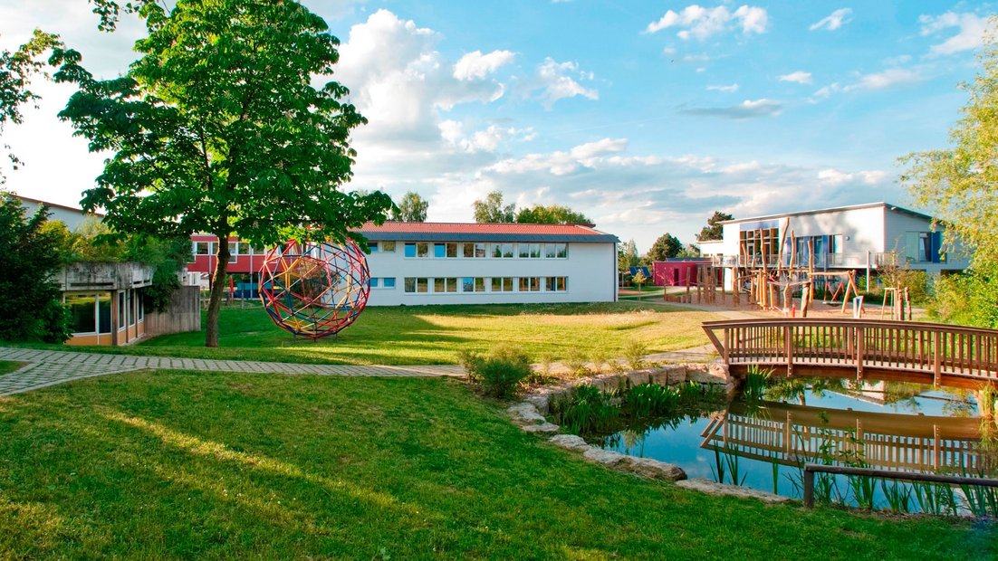 Terrain d’école avec étang et pont en bois