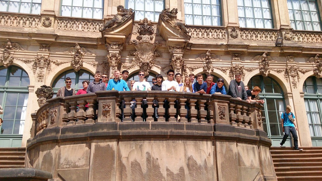 Un groupe d’étudiants se tient sur le balcon d’un bâtiment historique.